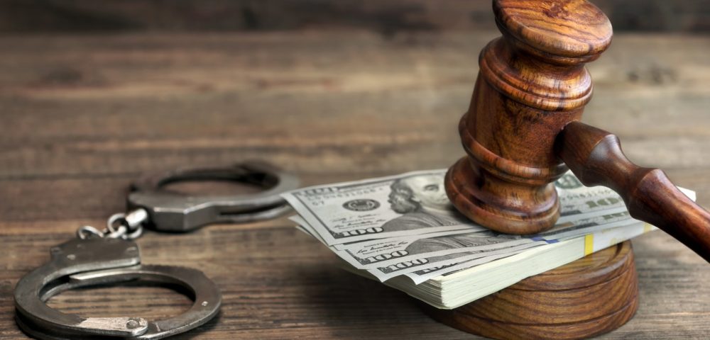 gavel pounding on money, handcuffs