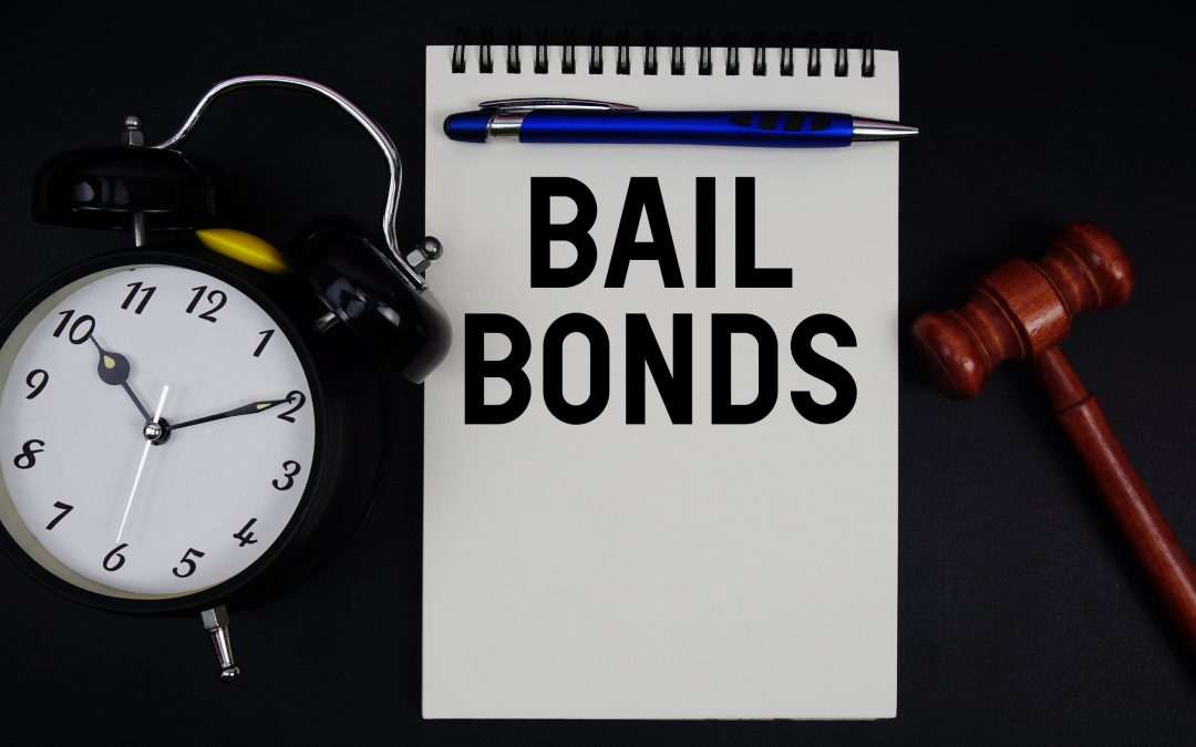 Bail Bonds text written on notepad with gavel and alarm clock on black background